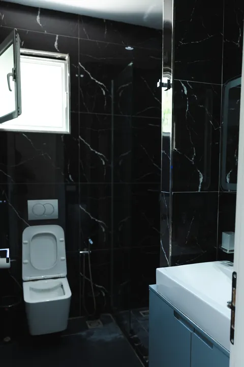 Black marble shower room with a frosted window