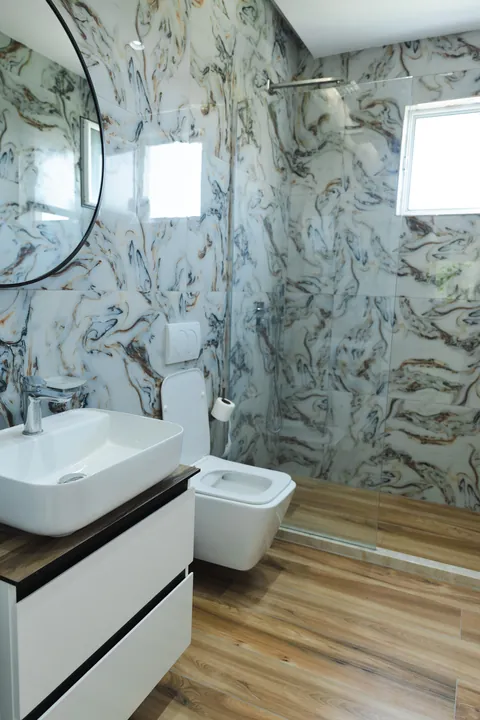 Bathroom with marble-effect tiles, vessel basin and walk-in shower